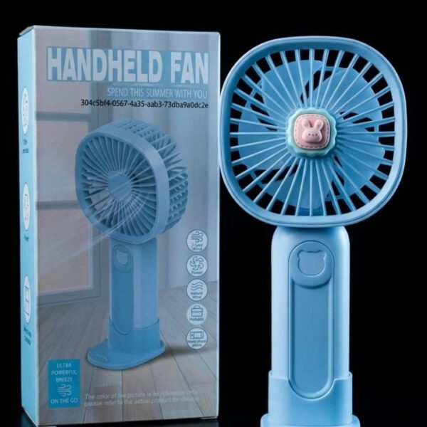 : Light blue portable handheld fan with cute bunny emblem standing next to its box packaging.